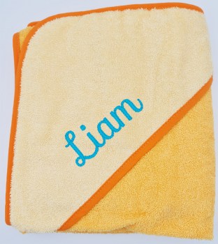 Gelbes Baby Kapuzenbadetuch mit hellgelber Kapuze, orangefarbener Einfassung und türkis eingesticktem Namen Liam